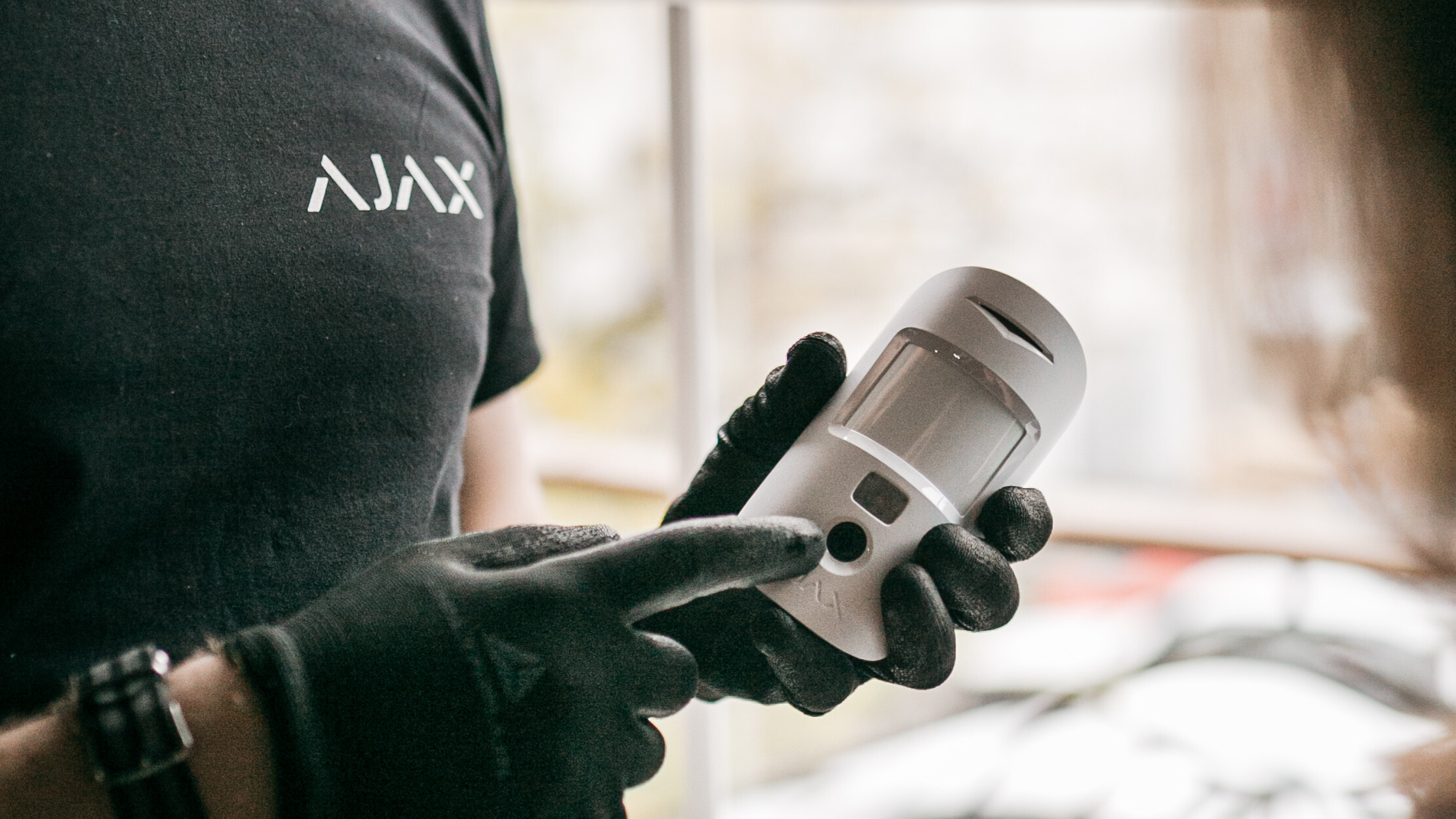 Ajax Installateur mit Motion Cam in der Hand